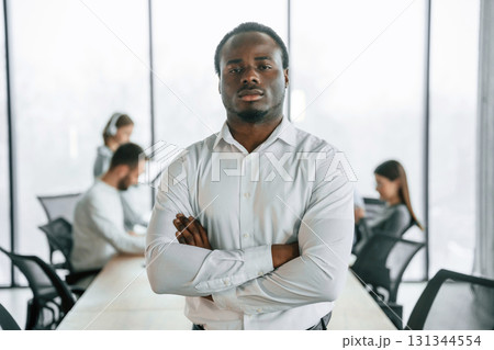 African American man is standing. Team of office workers are together indoors 131344554