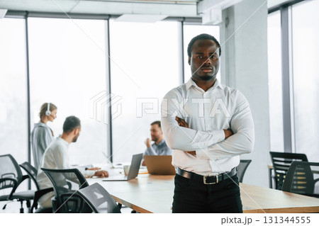 African American man is standing. Team of office workers are together indoors 131344555
