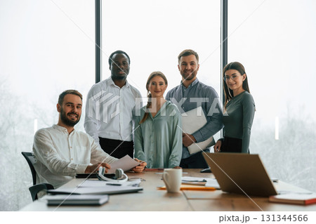 Posing for the camera. Team of office workers are together indoors 131344566
