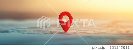 Red push pin marking a location on a map during sunset, representing themes of navigation, travel, tourism, and exploration in a vibrant golden hour light 131345011