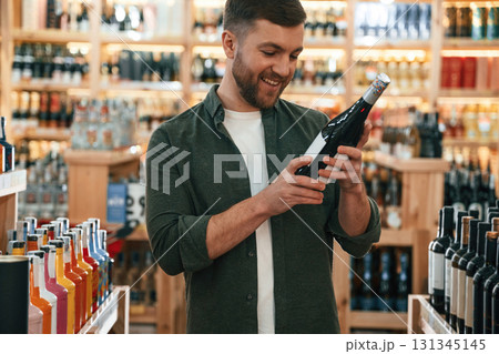 Front view. Man is choosing wine in the store 131345145