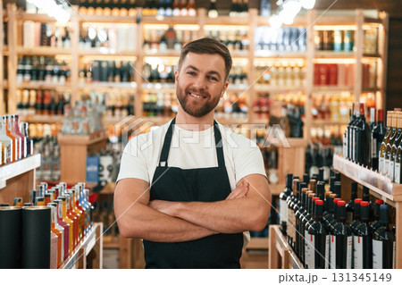 With arms crossed. Wine shop owner in white shirt and black apron 131345149