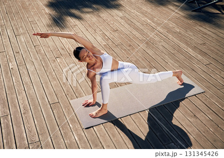 Professional yoga practitioner. Young woman in fitness clothes is outdoors 131345426