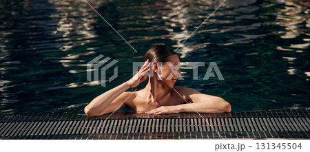 Portrait of happy woman in swimming pool Portrait of happy woman in swimming pool 131345504