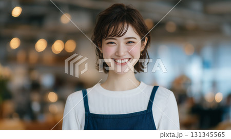 カフェスタッフの笑顔の女性・エプロン姿の明るく爽やかなポートレート 131345565