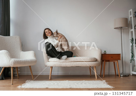 Playing together. Young woman is with her pug dog at home 131345717