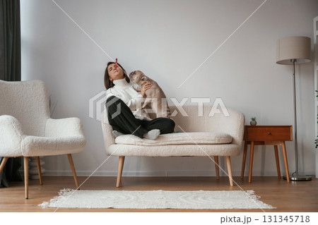 Playing together. Young woman is with her pug dog at home Playing together. Young woman is with her pug dog at home 131345718
