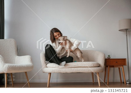 Young woman is with her pug dog at home 131345721