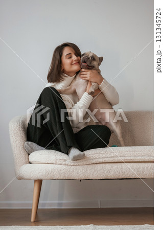 Sitting together. Young woman is with her pug dog at home 131345724