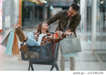 Riding in a shopping cart. Young couple are in supermarket together Riding in a shopping cart. Young couple are in supermarket together 131346240
