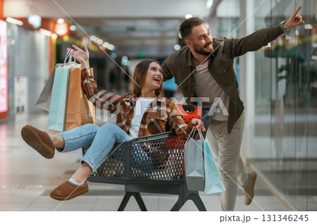 Fun in the mall, riding the shopping cart. Young couple are in supermarket together 131346245