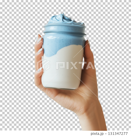 Hand holding a jar of blue yogurt smoothie, isolated on a transparent background. 131347277