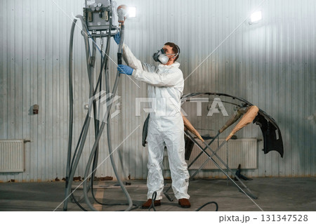 Metal carcass. Repairman is working in the garage Metal carcass. Repairman is working in the garage 131347528