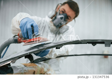 Polishing the surface. Repairman is working with carcass of the car in the garage 131347536