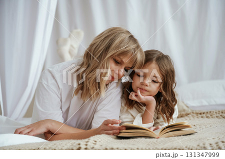 Reading the book together. Mother with daughter are at home 131347999