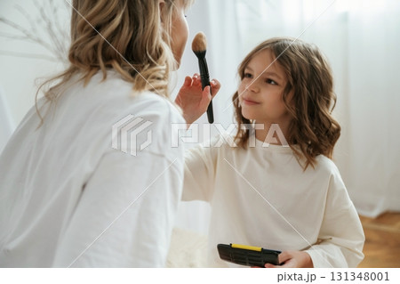 Doing make up. Mother with daughter are at home together 131348001