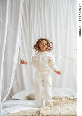 Having fun jumping on a bed. Cute little girl is at home Having fun jumping on a bed. Cute little girl is at home 131348037