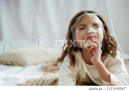 With beauty face mask. Cute little girl is at home With beauty face mask. Cute little girl is at home 131348047