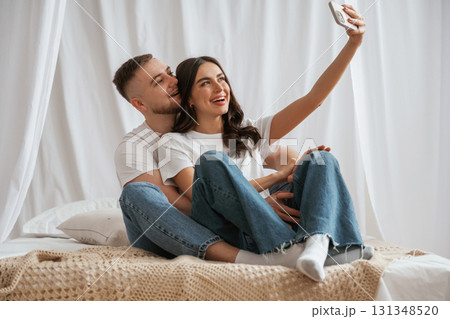 Using smartphone for selfie. Young couple are together at home Using smartphone for selfie. Young couple are together at home 131348520