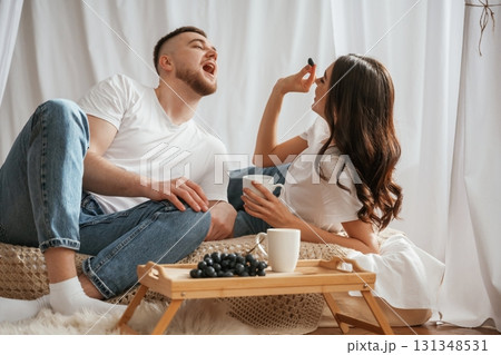 Grape and cups of drink. Young couple are together at home Grape and cups of drink. Young couple are together at home 131348531