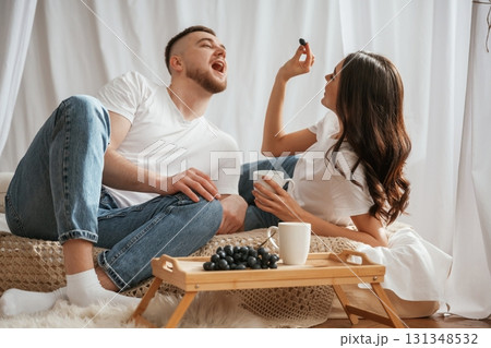 Grape and cups of drink. Young couple are together at home Grape and cups of drink. Young couple are together at home 131348532