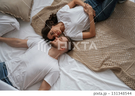 Top view, lying down. Young couple are together at home Top view, lying down. Young couple are together at home 131348544