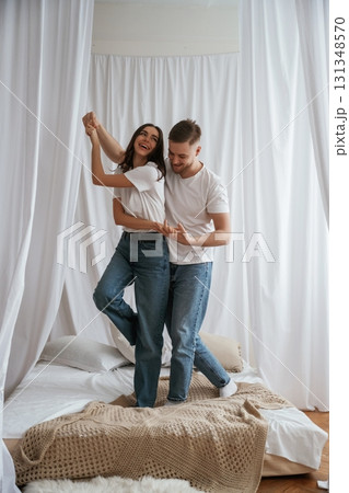 Standing and playing on the bed. Young couple are together at home 131348570