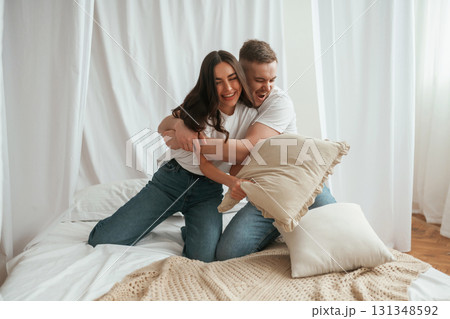 Soft pillows are in hands, playing. Young couple are together at home 131348592