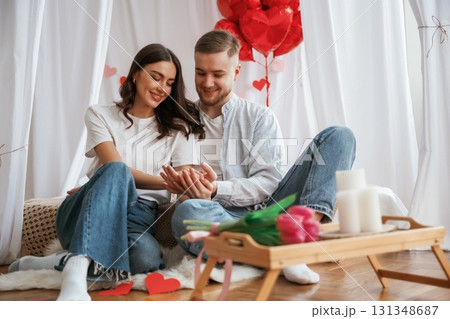 Celebrating Valentine's day holiday. Young couple are together at home 131348687