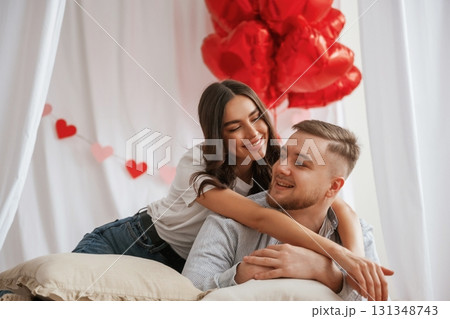 Bunch of heart shaped balloons, celebrating. Young couple are together at home Bunch of heart shaped balloons, celebrating. Young couple are together at home 131348743
