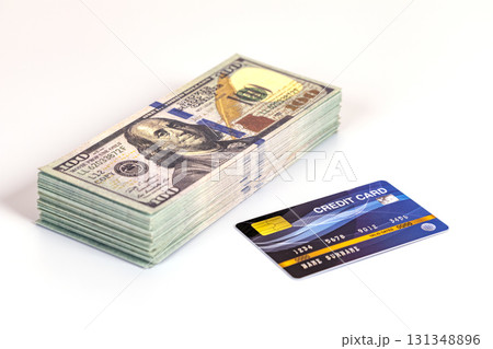 Stack of hundred dollar bill and credit card on white background showing financial comparison and decision making emotion Stack of hundred dollar bill and credit card on white background showing financial comparison and decision making emotion 131348896