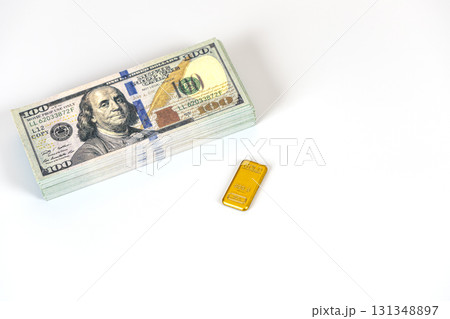 Stack of hundred dollar bills and small gold bar on white background conveying wealth and financial success with bright lighting and minimalist composition Stack of hundred dollar bills and small gold bar on white background conveying wealth and financial success with bright lighting and minimalist composition 131348897