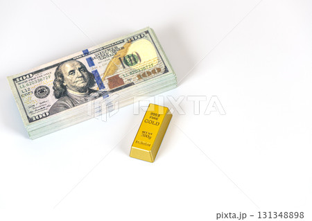 Stack of banknote and gold bar on white background conveying wealth and investment concept, bright lighting and clean composition with reflective metal and paper texture 131348898