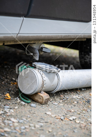 Camper van grey water drainage pipe system close up outdoors 131348954