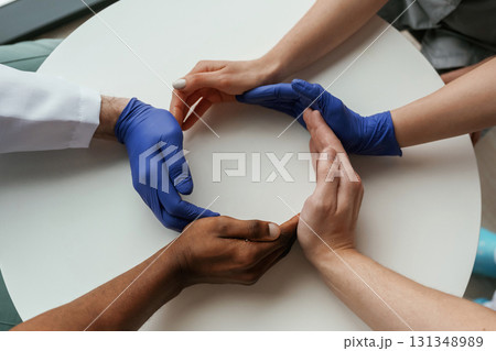 Circle shaped gesture. Group of doctors are holding hands in trust together 131348989