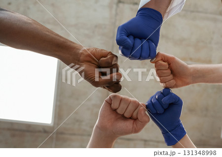 Group of doctors are holding hands in trust together Group of doctors are holding hands in trust together 131348998