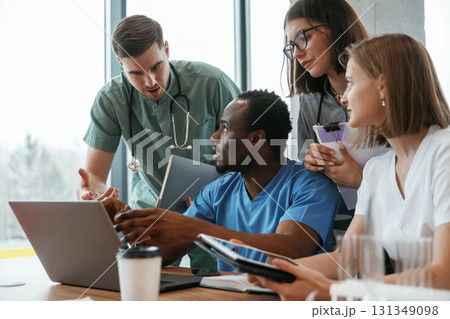 Reading information from laptop. Group of doctors are together indoors Reading information from laptop. Group of doctors are together indoors 131349098