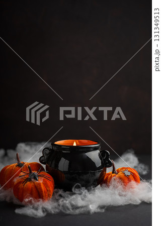 Halloween Candle in Cauldron with Pumpkins and Fog Halloween Candle in Cauldron with Pumpkins and Fog 131349513