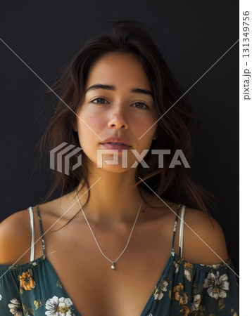 A woman with a necklace is standing in front of a black background 131349756