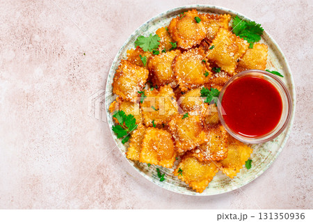 fried ravioli with parmesan cheese, served with red sauce and garnished with herbs, on a light background, no people, fried ravioli with parmesan cheese, served with red sauce and garnished with herbs, on a light background, no people, 131350936