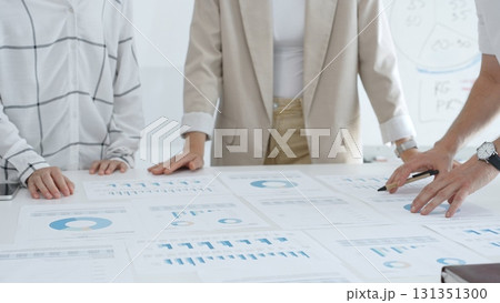 Business team analyzing financial charts and graphs, looking at statistics and discussing data, working together on business project in bright spacious office. Business people concept Business team analyzing financial charts and graphs, looking at statistics and discussing data, working together on business project in bright spacious office. Business people concept 131351300