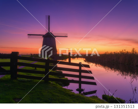 Windmill and fence in the Netherlands. A historic building in the Dutch countryside. Windmill and fence in the Netherlands. A historic building in the Dutch countryside. 131351513