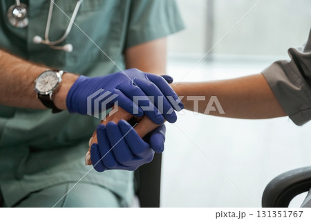 Blue gloves. Two doctors are holding hands indoors 131351767