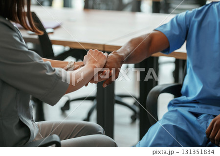 Two doctors are holding hands indoors 131351834