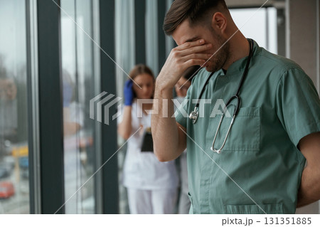 Guy is feeling bad. Group of doctors are together indoors 131351885
