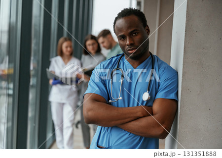 African American man is standing in front of colleagues. Group of doctors are together indoors 131351888
