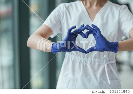 Female doctor showing heart gesture by hands, close up view 131351940