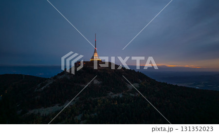 Jested Mountain Hotel stands tall at dusk in Liberec, Czechia. The modern structure is illuminated against the darkening sky, creating a stunning evening scene. 131352023