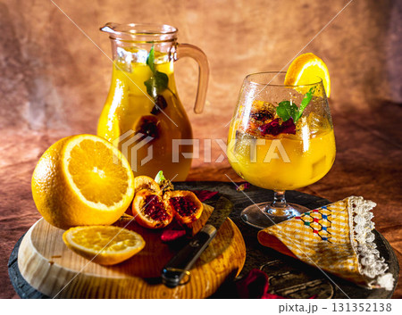 Refreshing orange cocktail with pitcher and fresh fruit 131352138