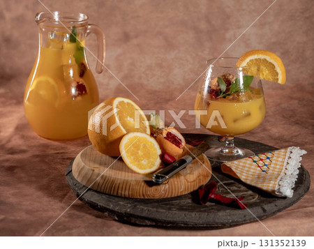 Refreshing orange cocktail with pitcher and fresh fruit 131352139